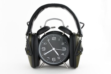 Poster - Close up shot of an alarm clock muted by a headset - working responsibilities and deadline concept