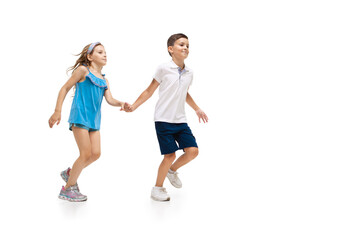 Wall Mural - Happy kids, little and emotional caucasian boy and girl jumping and running isolated on white background. Look happy, cheerful, sincere. Copyspace for ad. Childhood, education, happiness concept.