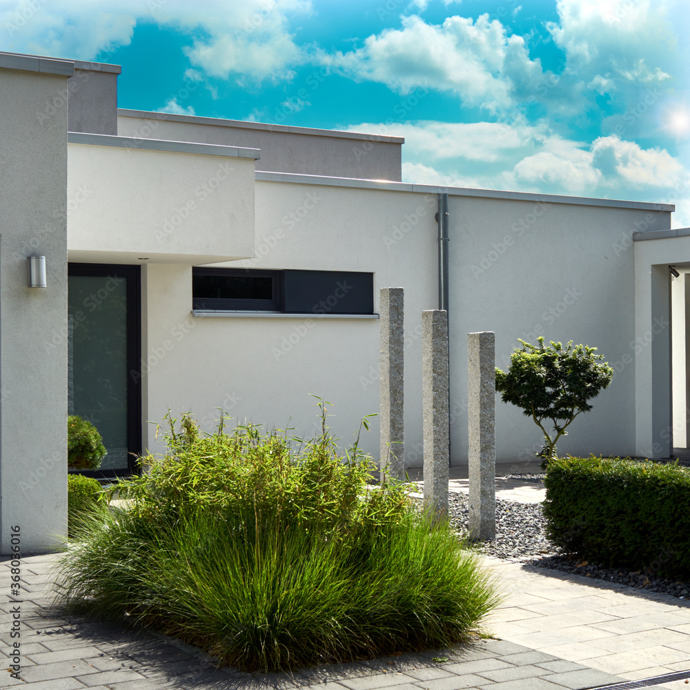 Front garden of a modern minimalist house with stone pillars and a ...