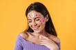 Image of young joyful woman with stickers on face laughing at camera