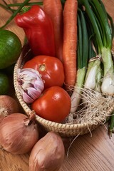 Wall Mural - vertical shot of a basket with fresh vegetables and eggs on a brown table