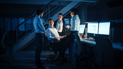 Wall Mural - Late at Night In Modern Office: Diverse Team of Successful and Ambitious Businessmen and Businesswomen Gather Around Computer, Have Discussion, Find Problem Solution, Finishing Project Together