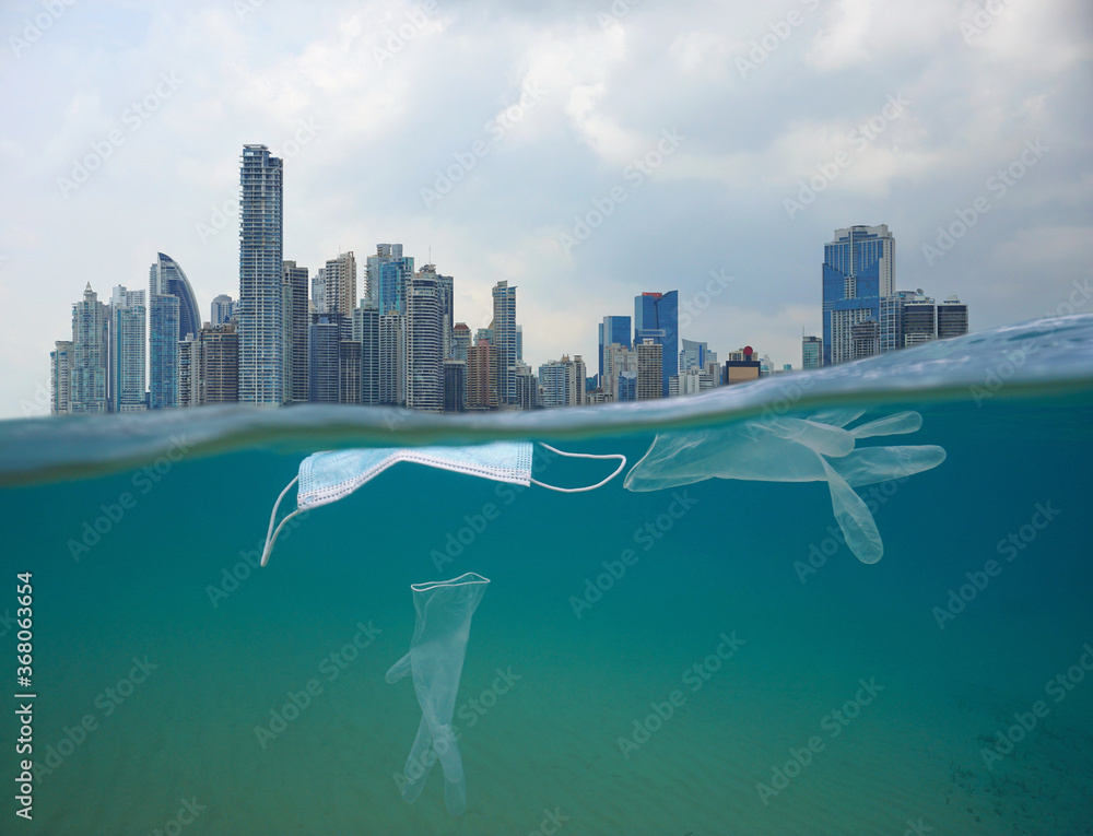 Plastic waste pollution in the ocean, face mask with gloves underwater and city buildings with cloudy sky, coronavirus COVID-19 pandemic, split view over and under water surface - obrazy, fototapety, plakaty 