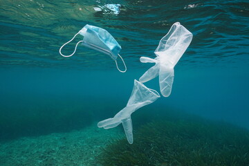 Wall Mural - Disposable gloves and face mask underwater, plastic waste pollution in the sea since coronavirus COVID-19 pandemic