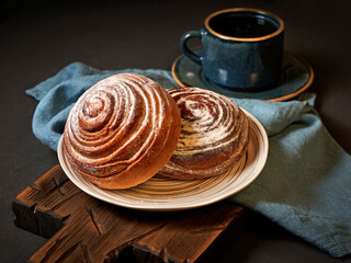 Two powdered sugar cinnabons on white plate