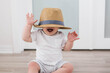 © Tamara Sales  - baby playing with a straw hat covering his eyes stock photo