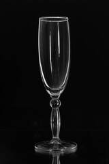 There is an empty wine glass on the table. The glass is on a black background