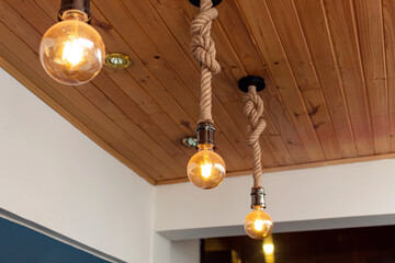 three artesanal yellow light bulbes with wooden roof and blue & white paiting. Interior design concept