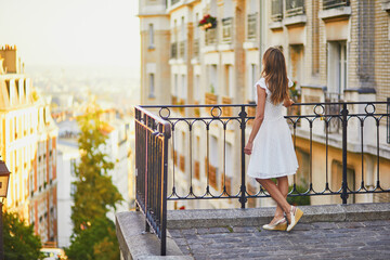 Wall Mural - Woman in white dress walking on famous Montmartre hill in Paris, France at early morning