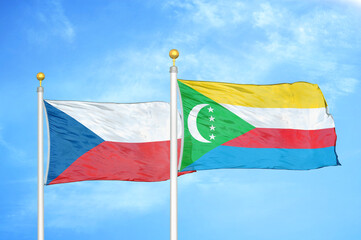 Czech and Comoros two flags on flagpoles and blue cloudy sky