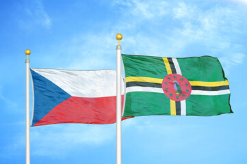 Czech and Dominica two flags on flagpoles and blue cloudy sky