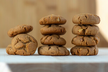 Very tasty peanut butter biscuits on bamboo light brown wooden board, golden baked healthy