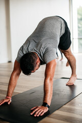 Young man stretching and doing yoga in the gym 