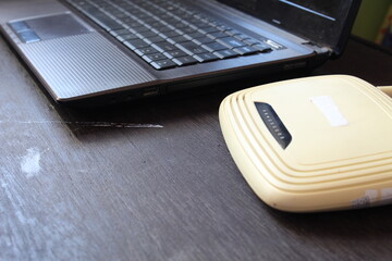 Wireless router and laptop on wooden table