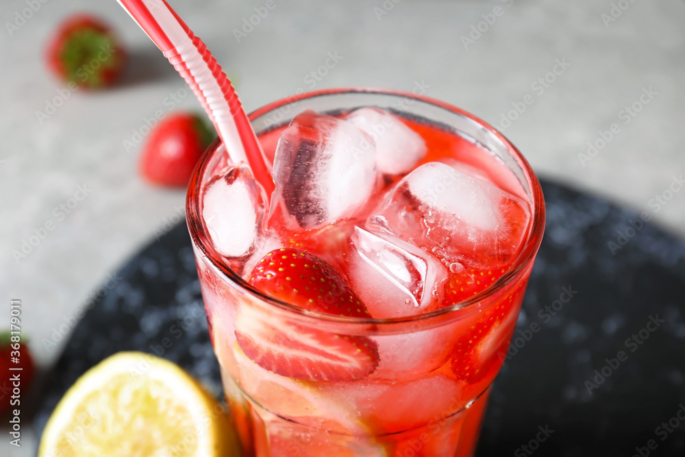 Glass of fresh strawberry lemonade on table, closeup