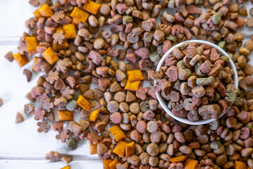 Wall Mural - Top view of colorful dry pet food in a white ceramic bowl