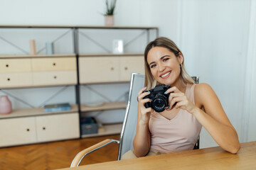 Wall Mural - Portrait of a beautiful woman with professional camera indoors.