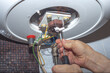 © dmf87 - Repairman hand are fixing broken electric boiler