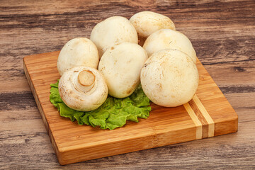 Raw champignons over the board