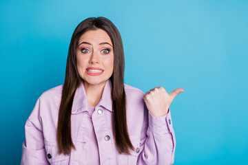 Sticker - Dont look there. Portrait of nervous anxious girl point thumb finger copyspace frightened corona virus terrible novelty wear good look clothes isolated over blue color background