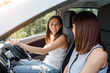 © Med Photo Studio - Two happy young women friends are driving a car and enjoy the company. T
