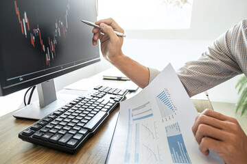 Wall Mural - Businessman working with computer and analyzing graph stock market trading