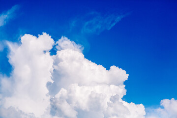 Large white air cloud in the blue sky. The weather forecast reports on partly cloudy weather and a change from cyclone to anticyclone. Environmentally friendly source of energy.