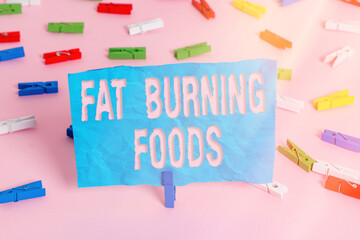 Conceptual hand writing showing Fat Burning Foods. Concept meaning produce fat loss by stimulating metabolism to reduce appetite Colored clothespin papers empty reminder pink floor office