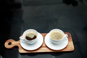 two coffee cup on wooden plate and in coffee shop angle view shot