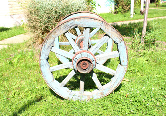 Old wooden wheels on the grass. Vintage concept.