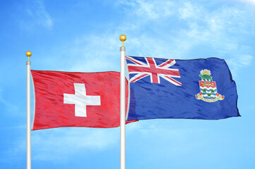 Switzerland and Cayman Islands two flags on flagpoles and blue sky