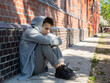 © polya_olya - A lonely, sad teenager sits alone on the street near the house. quarrel with parents, problems at school. problems and psychology of adolescents, concept