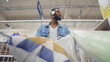 © TommyStockProject - Low angle view of cheerful african man in headphones shopping in house decoration store