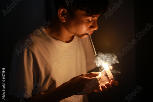 マッチでタバコに火をつける男性 Stock Photo Adobe Stock