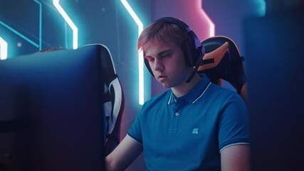 Wall Mural - Professional Gamer Plays Computer Video Game Talking into Headset with Teammates on a Championship