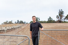 Young Farmer Opening A Gate On A Farm