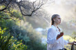 © Jonah Ritchie/Austockphoto - Young woman listening to music on smartphone while standing outdoors