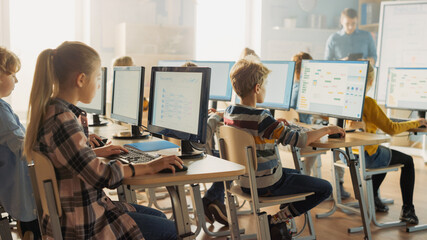 Wall Mural - elementary school computer science classroom: smart little schoolchildren work on personal computers