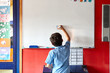 © Jonah Ritchie/Austockphoto - Young school boy at school writing on white board