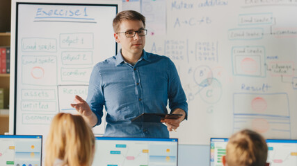 elementary school class: teacher uses interactive digital whiteboard, explains lesson to diverse gro