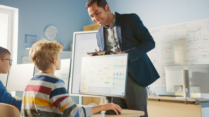 Wall Mural - elementary school computer science classroom: teacher uses tablet computer, explains lesson to diver