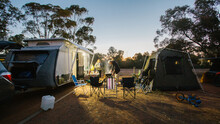 View Of People Cooking Outside Their Caravan Campsite At Sunset