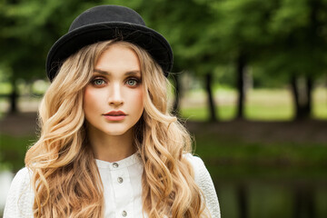 Wall Mural - Beautiful young woman in black hat outdoor