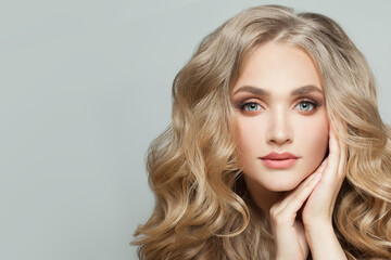 Wall Mural - cheerful young woman with healthy blonde wavy hair and clear skin on white