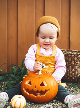 Happy Halloween! Child  With Pumpkins On Wooden Background.