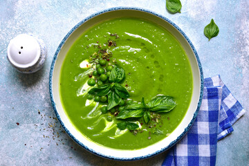 Pureed green pea soup with cream. Top view with copy space.