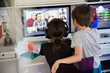 © Tom Merton/Caia Image - Kids video conferencing with friends on computer screen