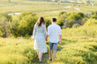 © Ivan Kozachenko - Pregnant woman holding hands with her husband during a walk in the field at sunset. Happy family and newborn.