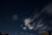 International Space Station ISS Trail Crossing Sky With Stars And Clouds Above City Houses
