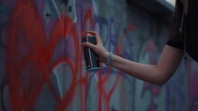 Woman Hand Painting Graffiti On Street Wall. Girl Drawing Red Heart On Building